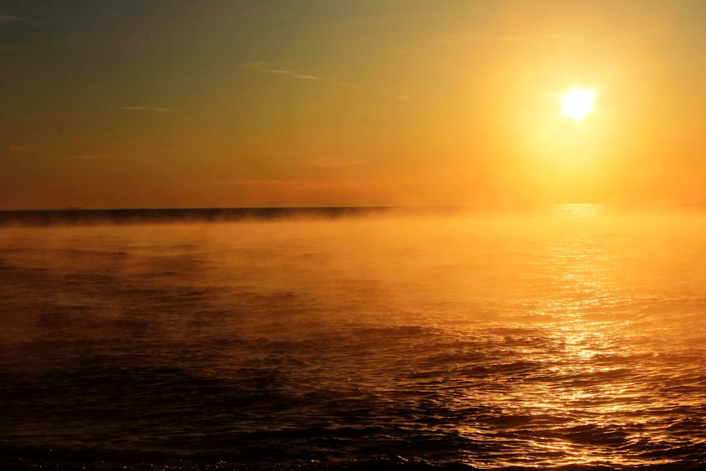 landscape photography of sun near body of water