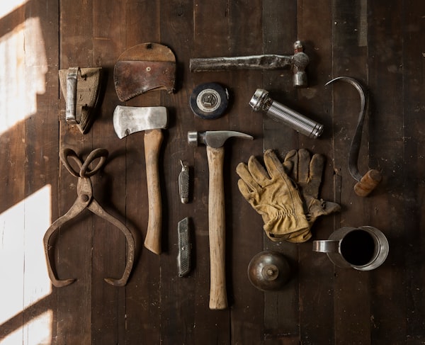 A spread of various tools laid on a wooden floor