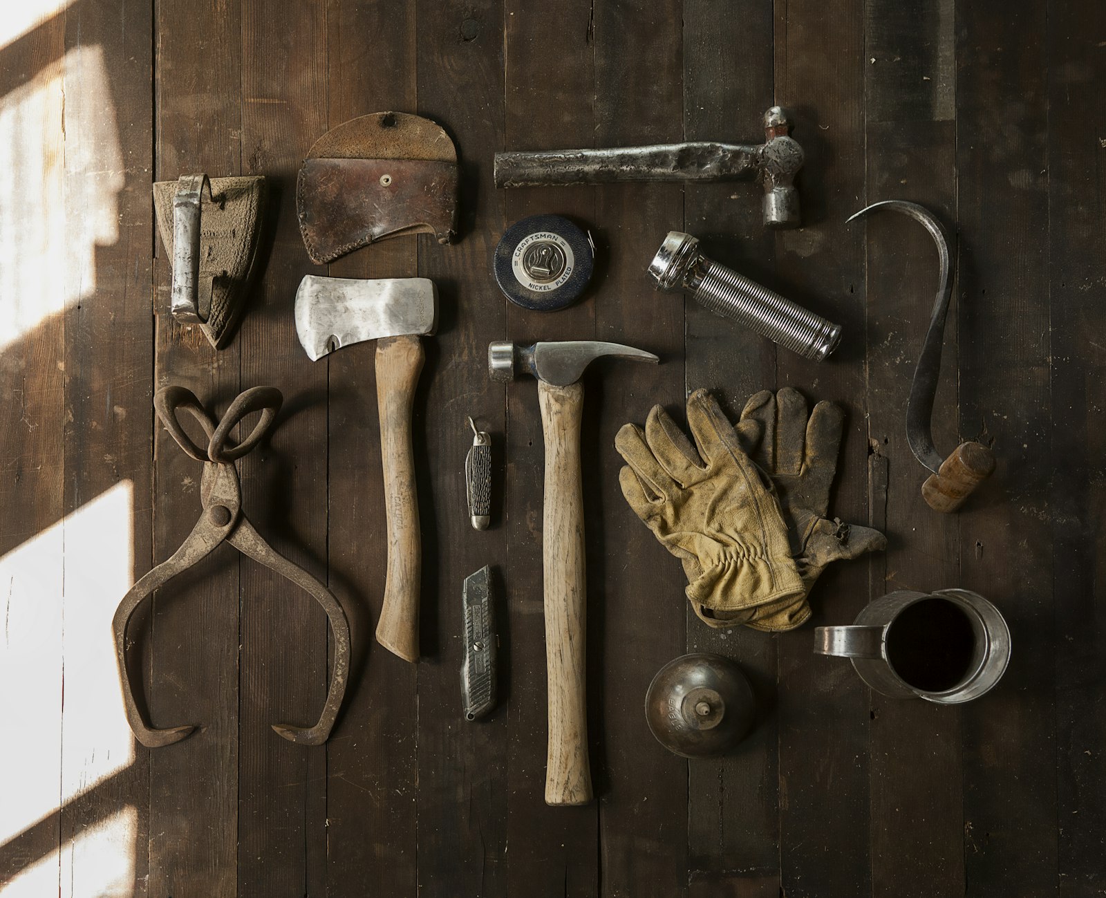 Clothes iron, hammer, axe, flashlight and pitcher on brown wooden table