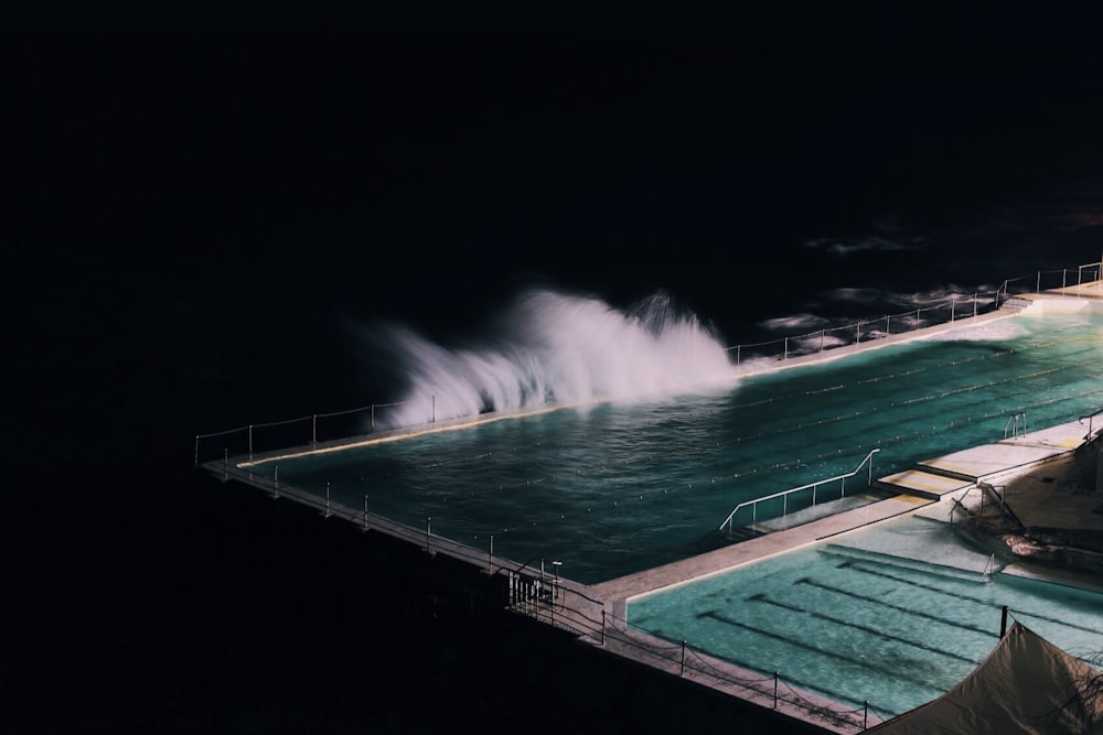 rectangular blue swimming pool during night time