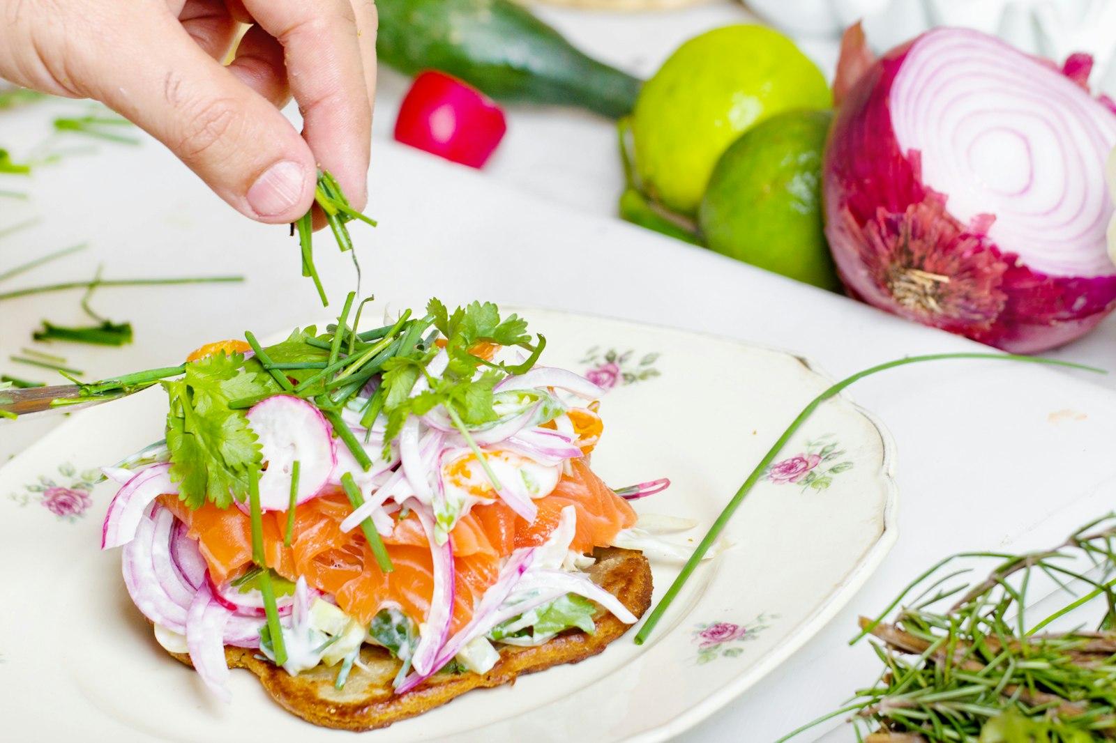 Hand garnishing toast with herbs