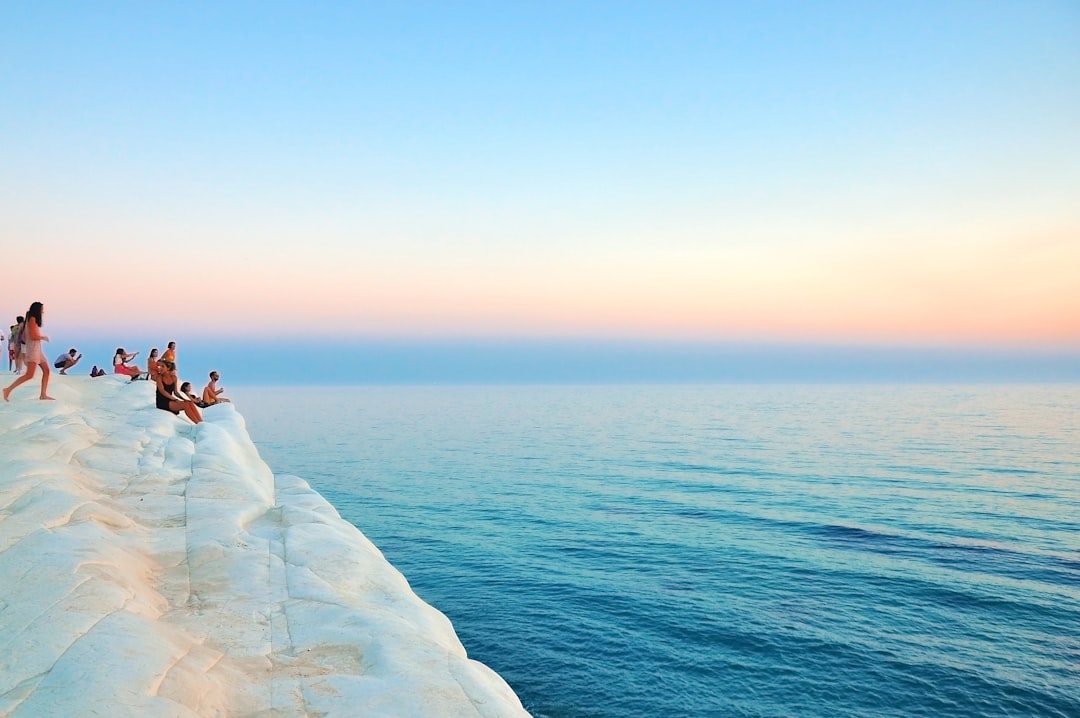 group of people sitting on white limestone, Scala dei Turchi cliff