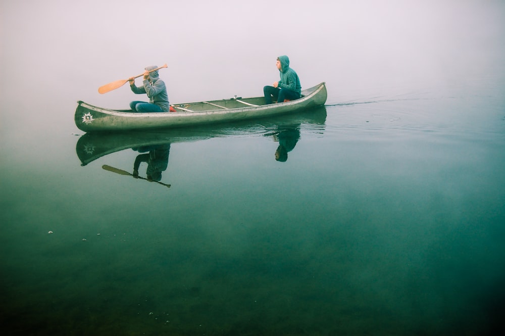 men riding on canoe