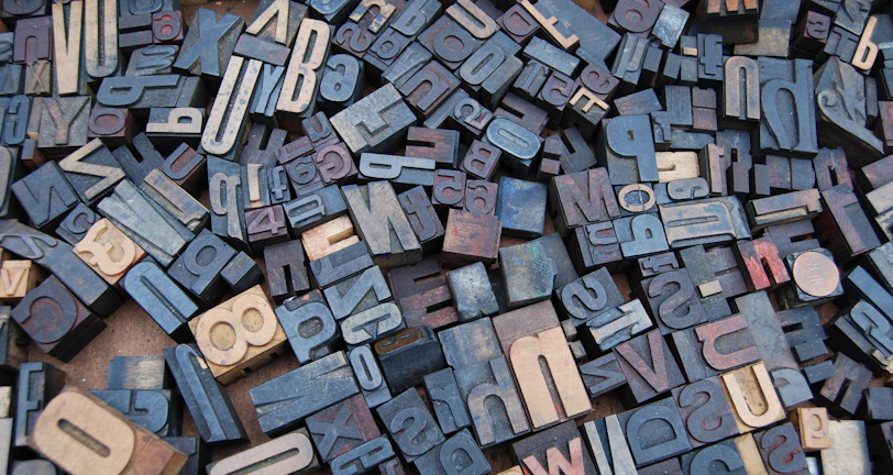Collection of different ligature designs displayed on a modern wooden surface