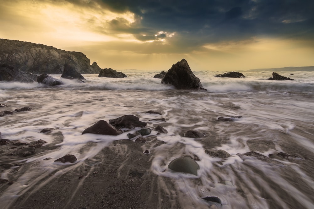 rock formation beside body of water