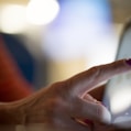 selective focus photography of person pointing at tablet computer