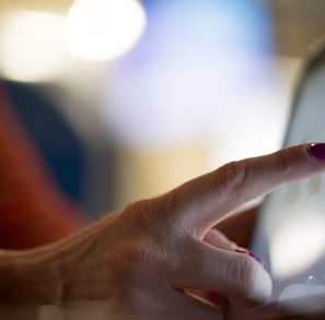 selective focus photography of person pointing at tablet computer