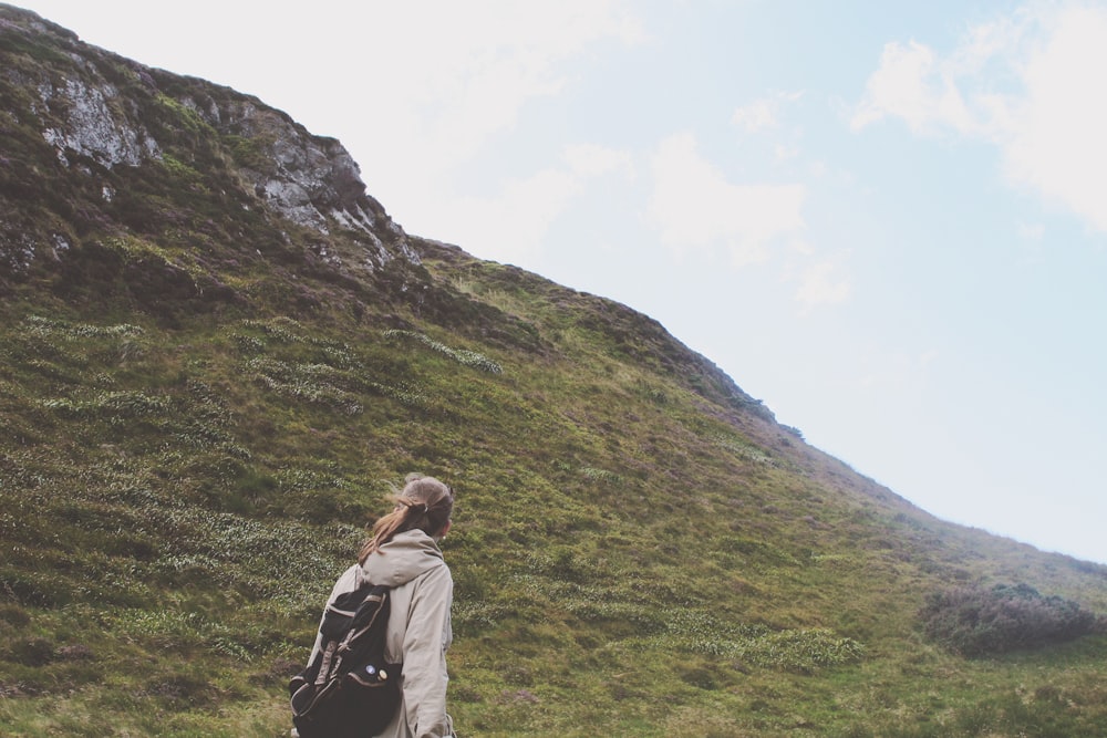 person walking on green mountain