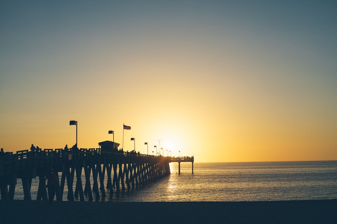 silhouette shot of dock and beach