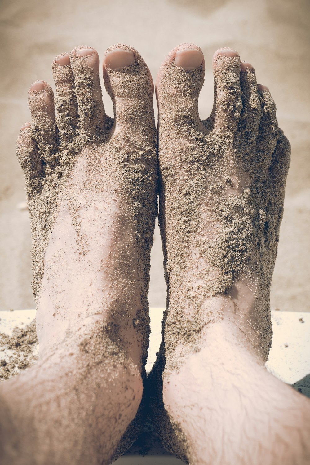 closeup photo of person's feet covered with sand