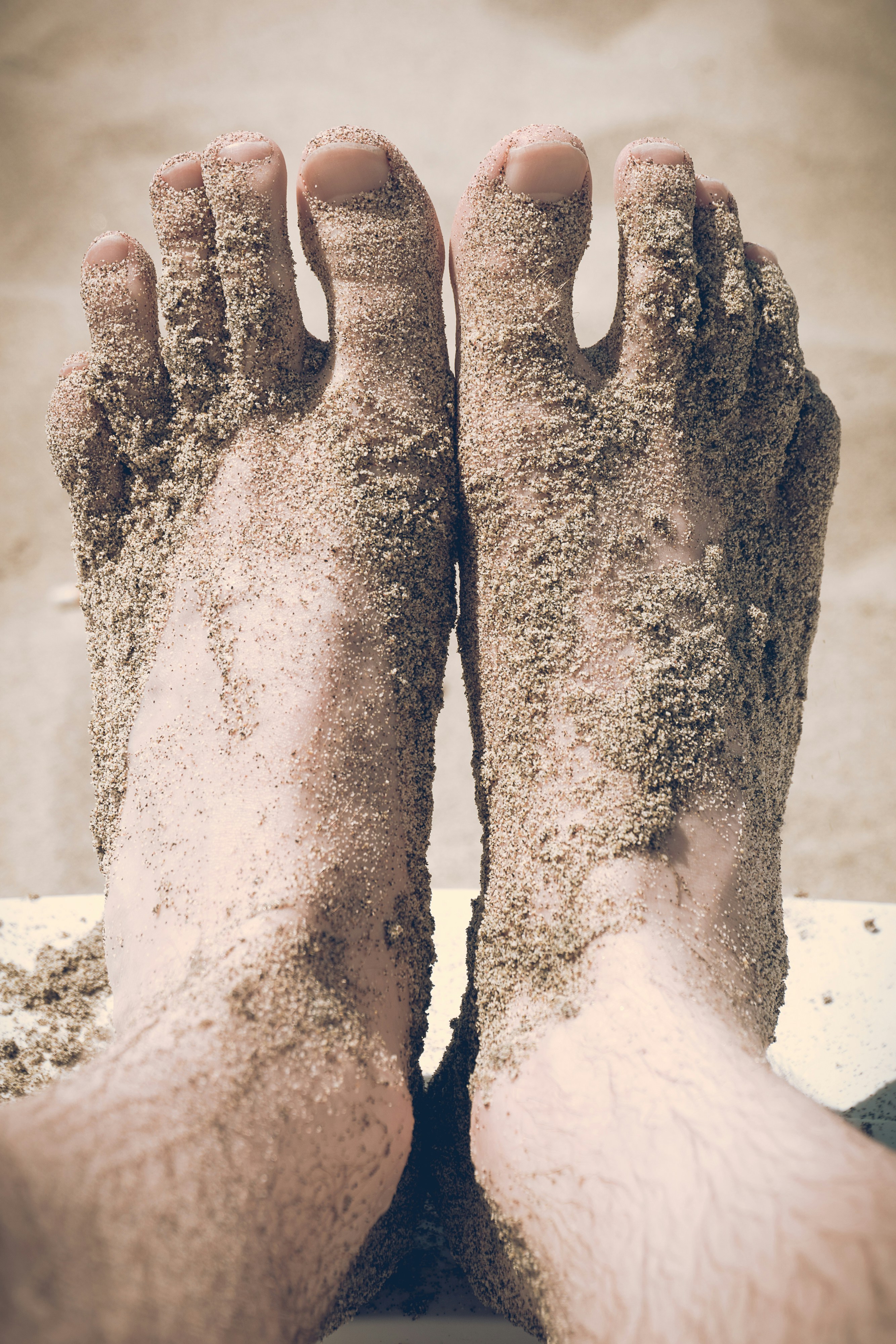 Feet covered in beach sand