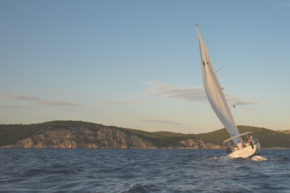 white sailing boat on body of water