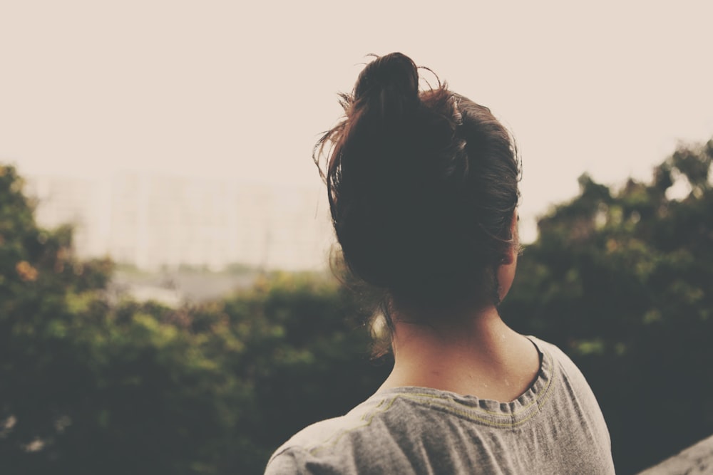 Photographie de mise au point d’une femme face à des arbres