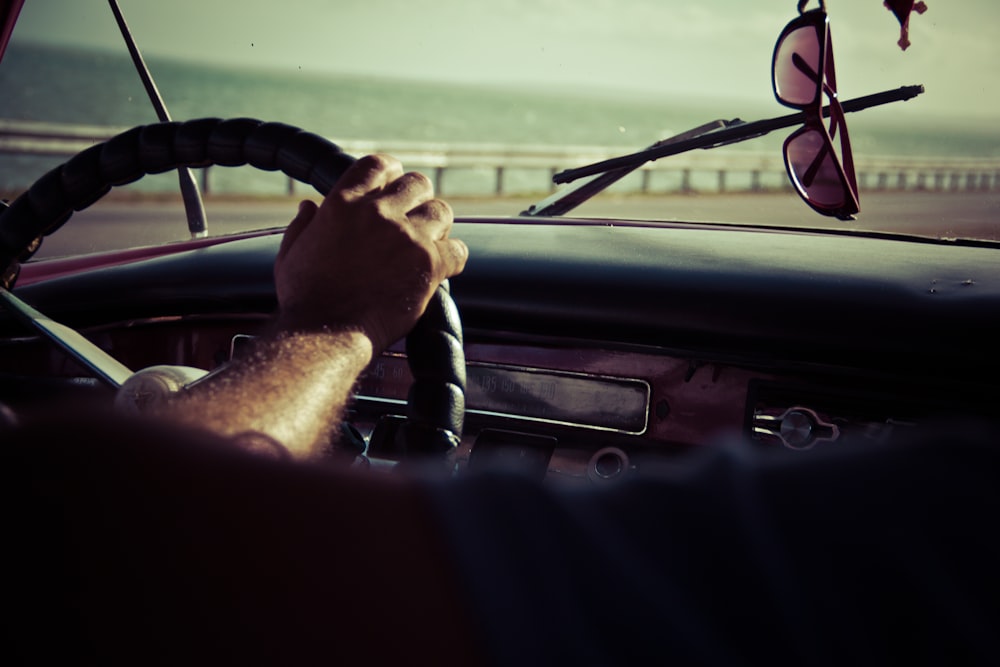 person holding steering wheel