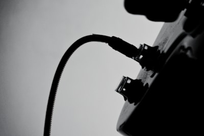 A modern, simple illustration of an electric plug connecting to a power socket with a subtle tree silhouette in the background.