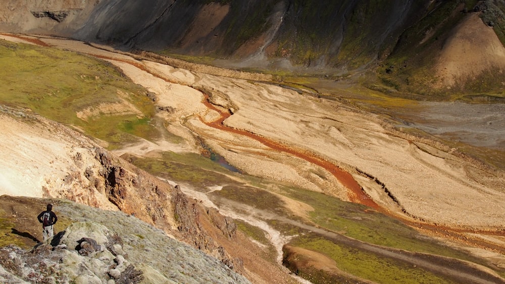 bird's eye view of man standing on gray mountain