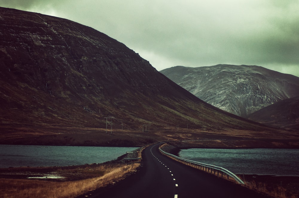 concrete bridge near mountains during daytime