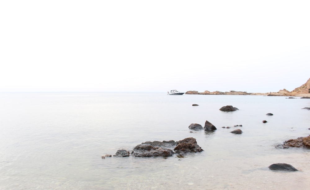 body of water near rocks at daytime