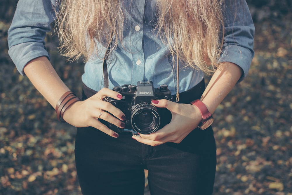 photo of woman holding MILC camera