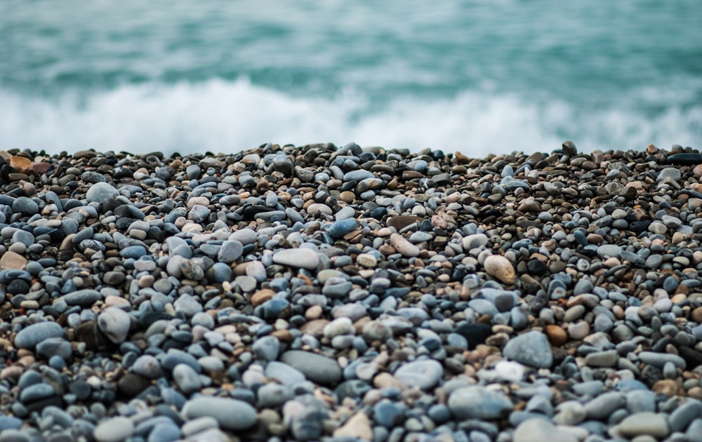 gray and black stones near sea at dayime