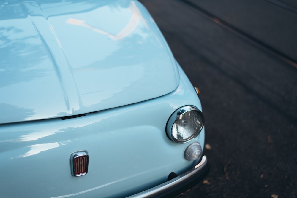 white FIAT car parked on asphalt road