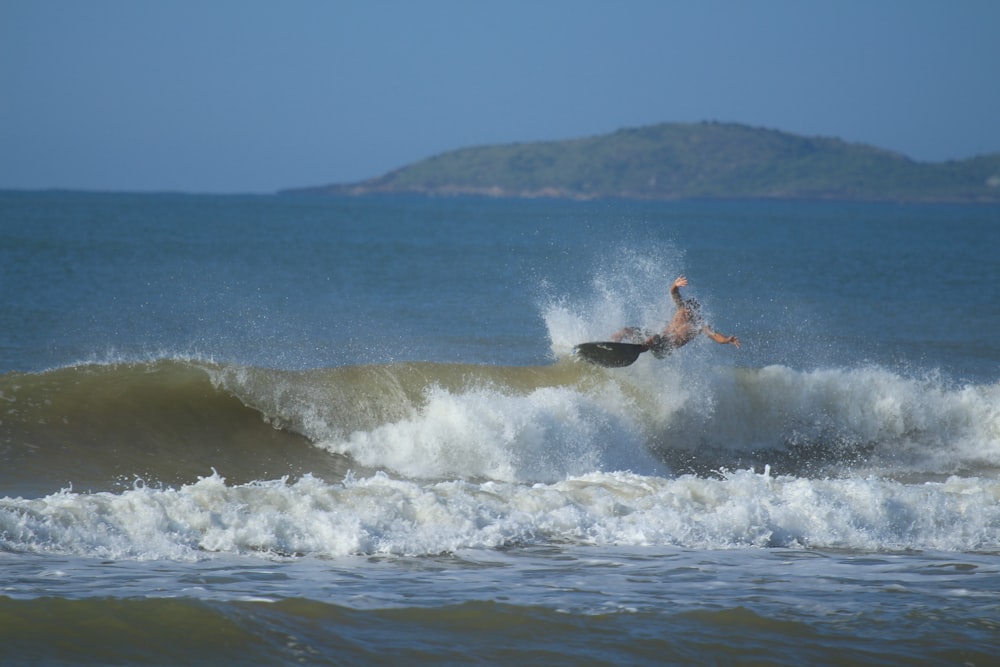 Zeitrafferfotografie einer Person, die auf einer großen Welle surft