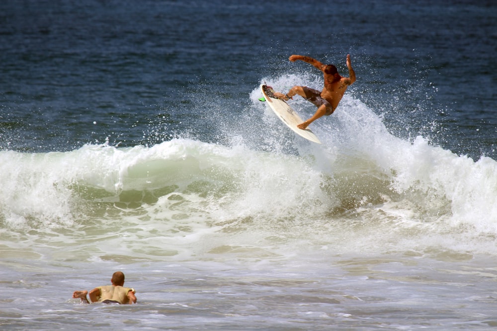man surfboarding on ocean wave during daytime