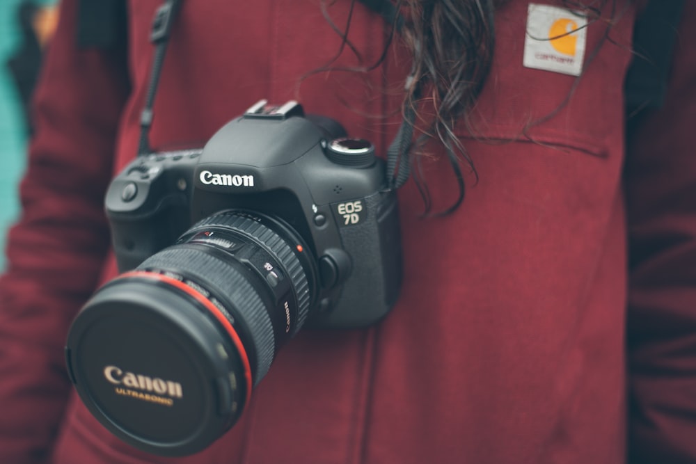 person wearing Canon DSLR camera