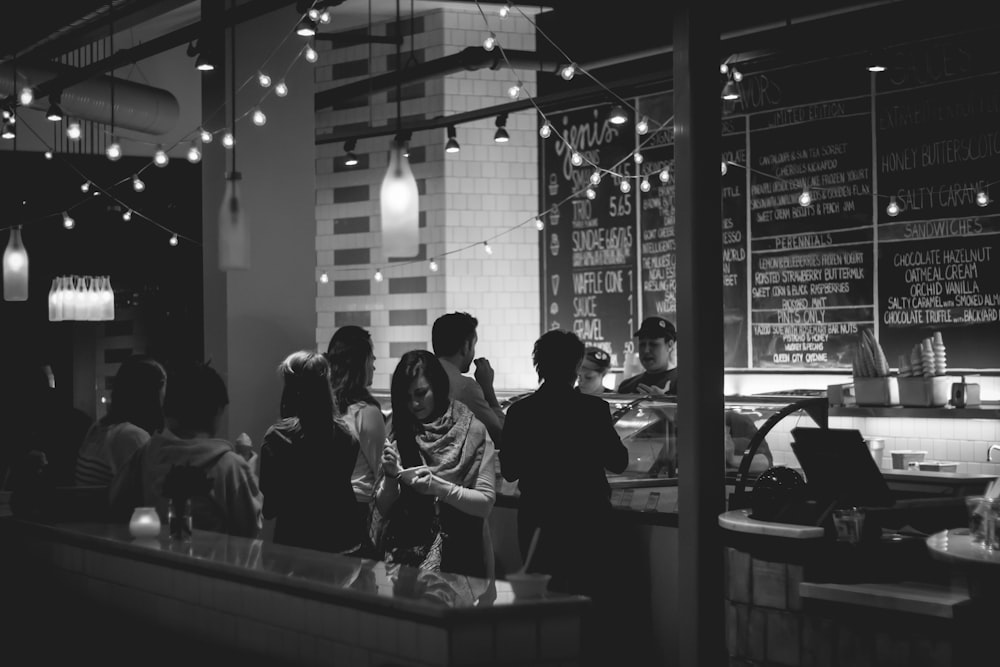 grayscale photography of people standing in line