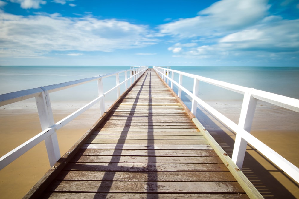 brown and white wooden dock under white clouds