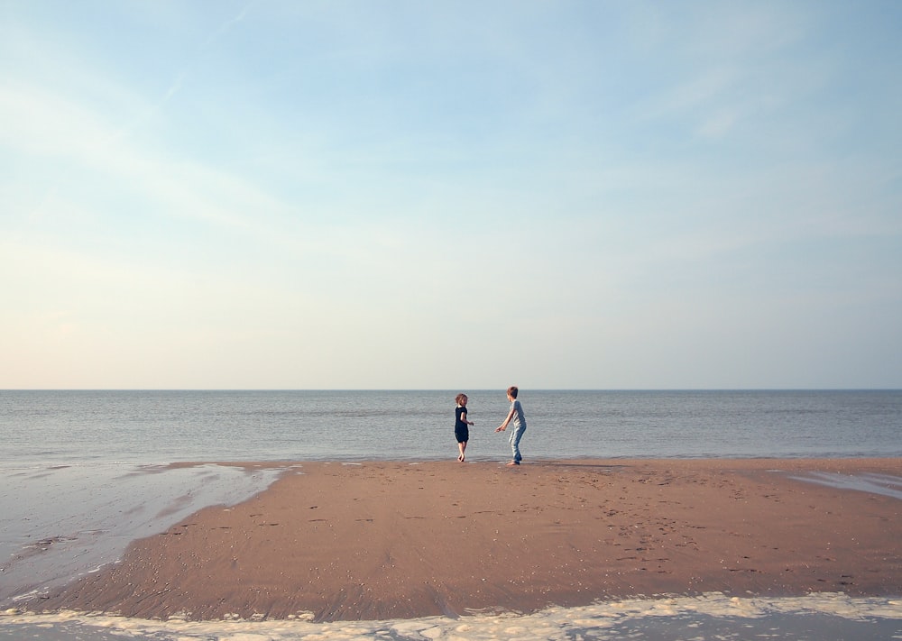 two woman playing in shoreline