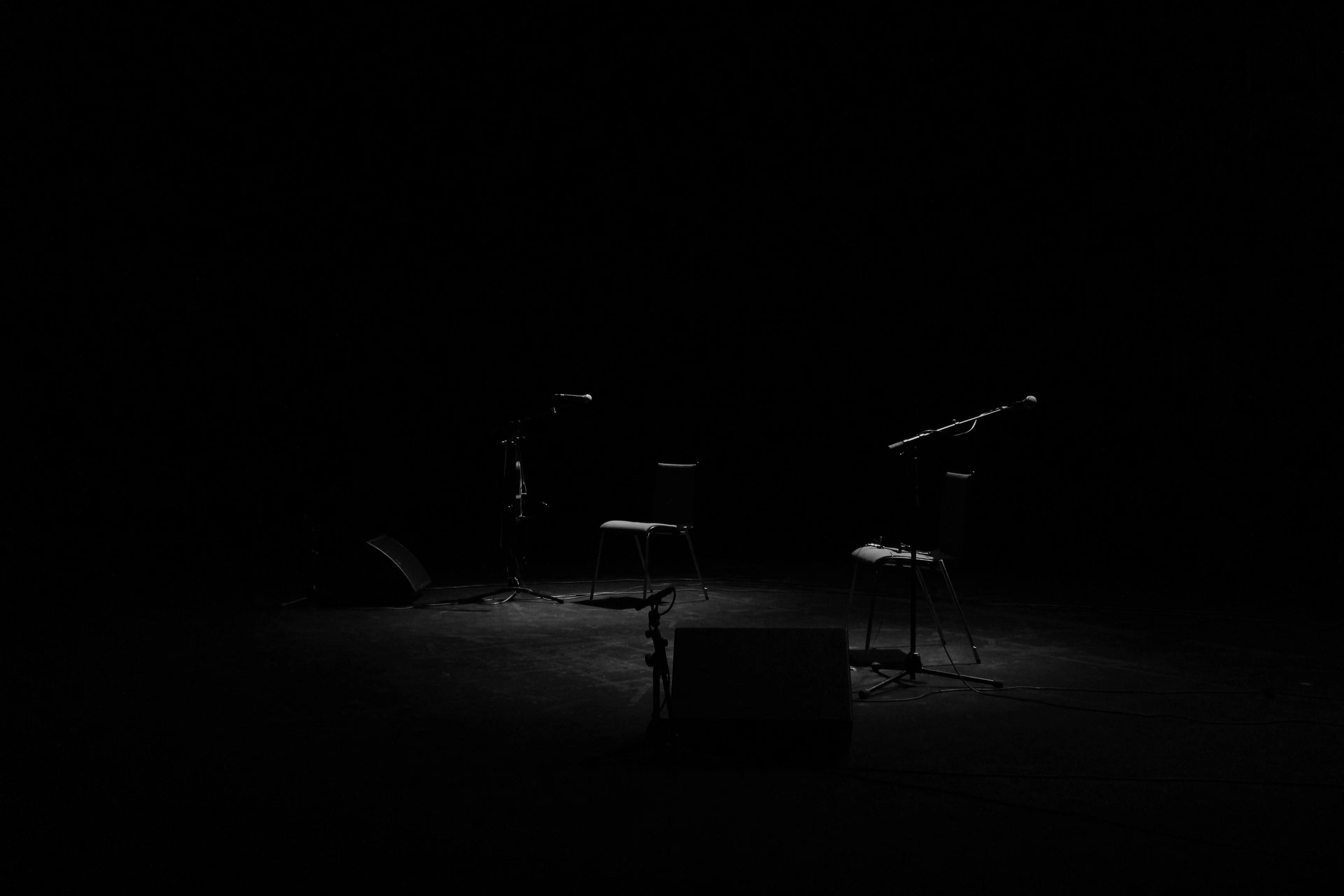 An empty stage with chairs and microphone stands