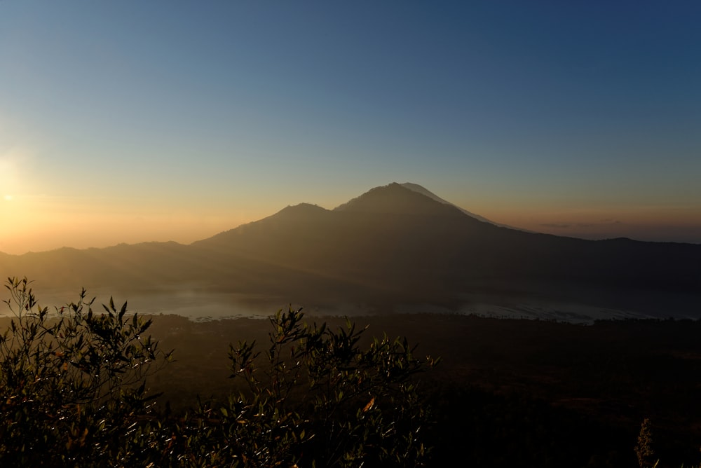 mountain view with fog under clear blue sky at daytime