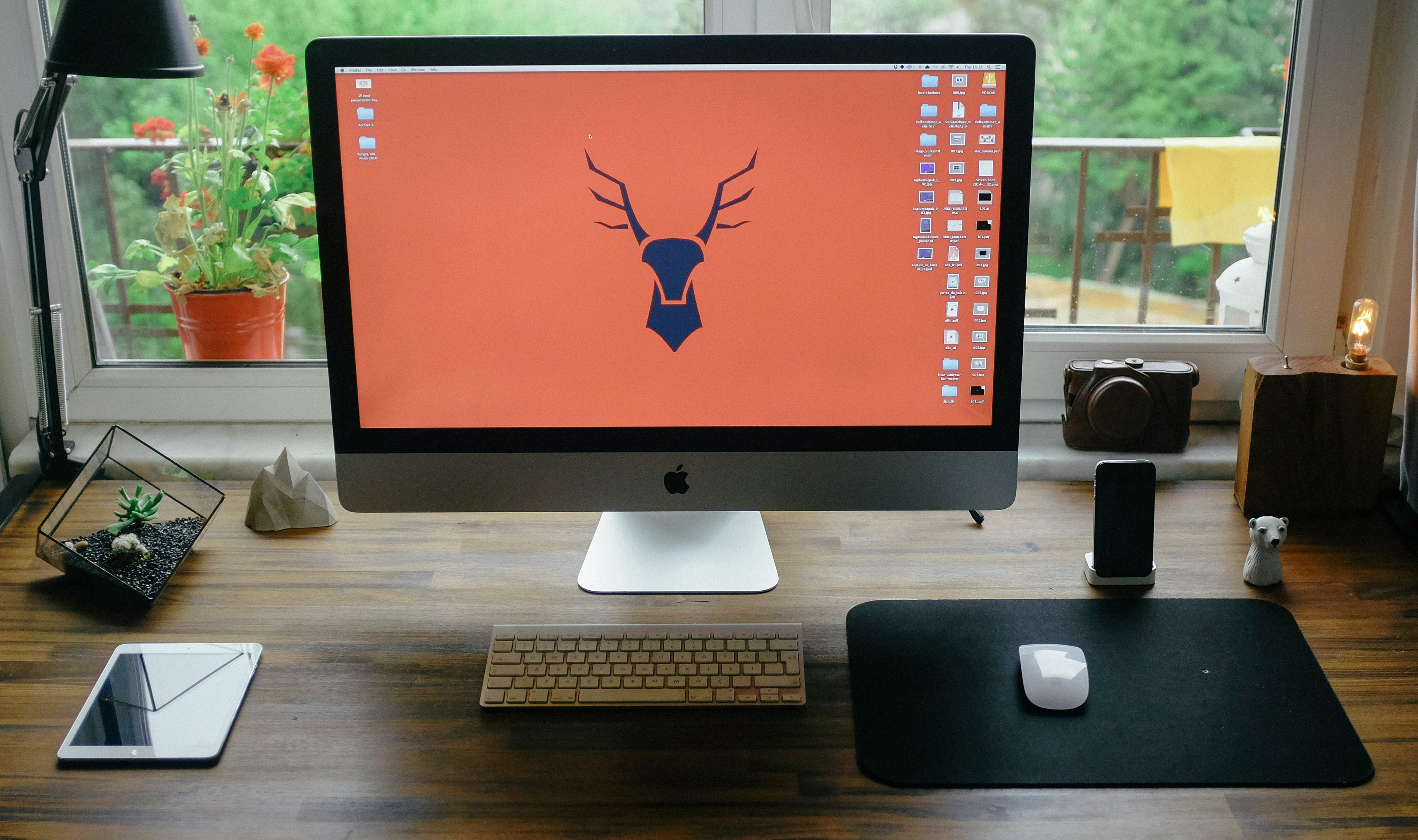 silver iMac on brown wooden table