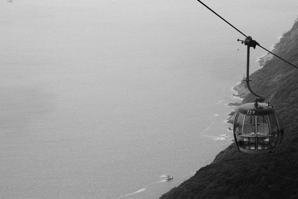 grayscale photography of cable car distance with sea