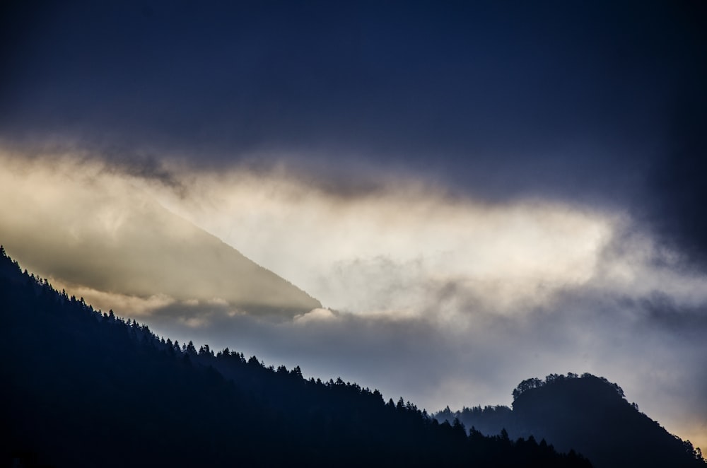 silhouette of mountain under clouds