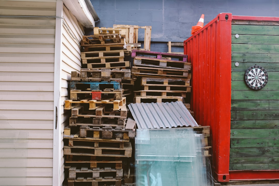 brown wooden crate lot between red and green shipment container