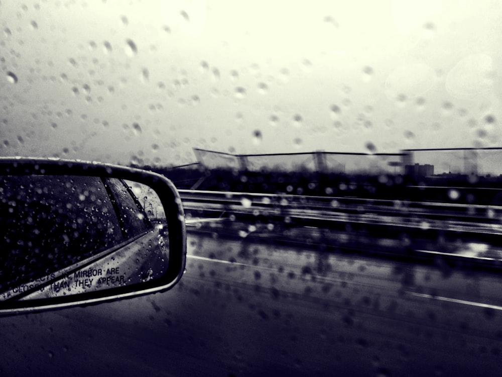 selective focus grayscale photography of side mirror and windshield with water dew
