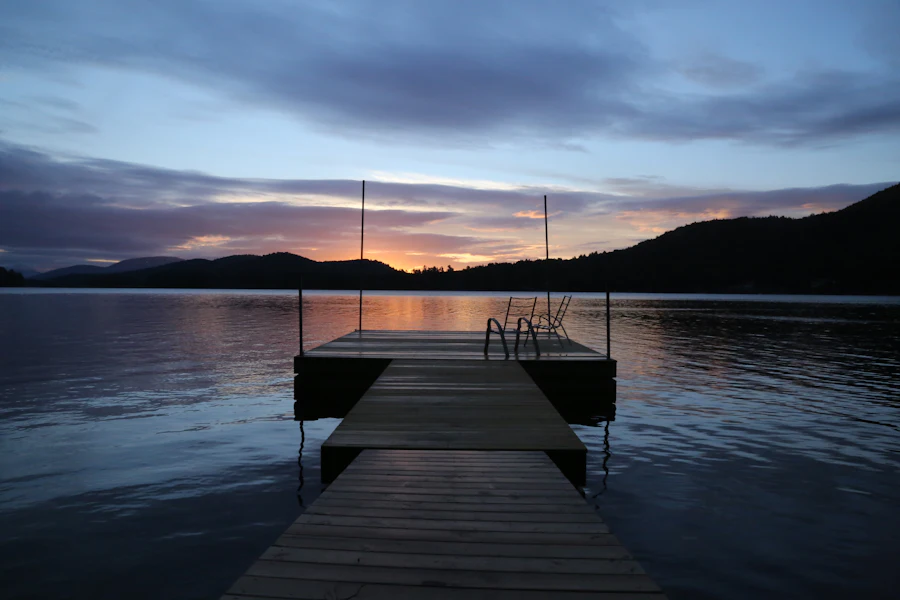 View down a wooden dock over the lake at twilight