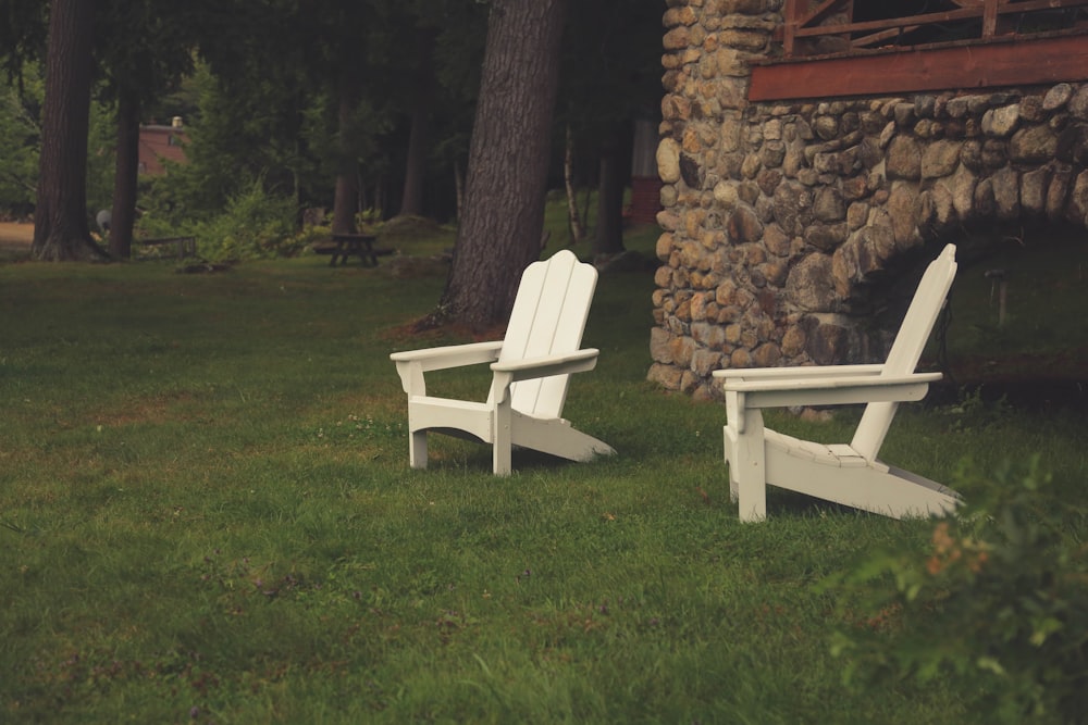 Dos sillones de madera blanca sobre césped