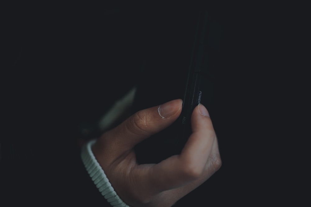 une personne tenant un téléphone cellulaire à la main