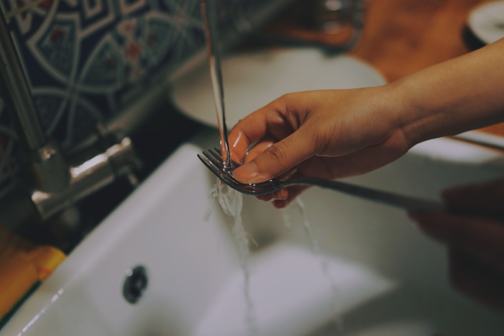 person washing fork