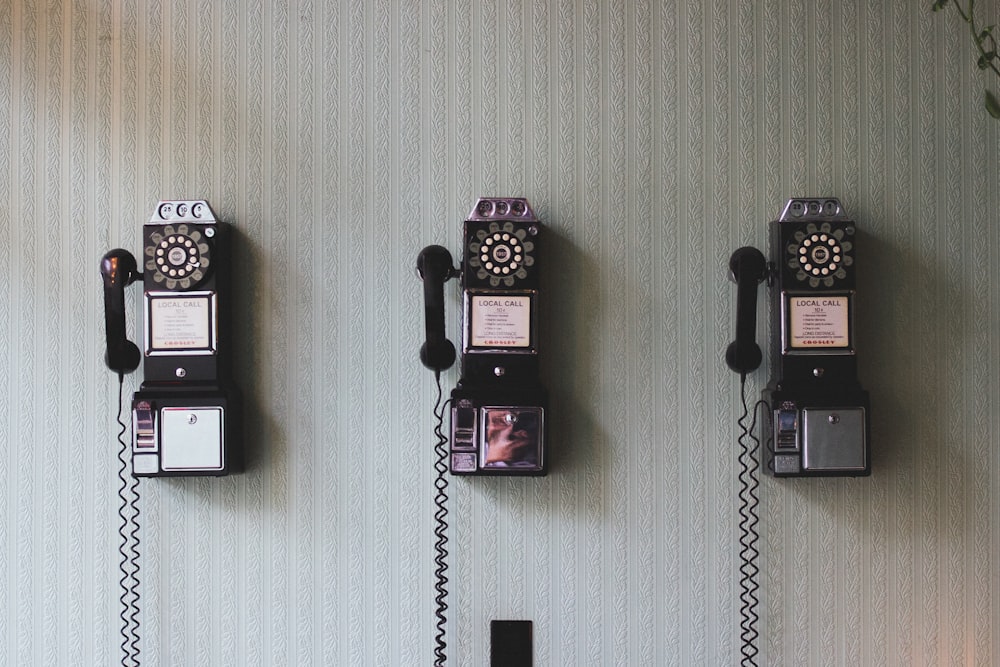 fotografia minimalista di tre telefoni a manovella