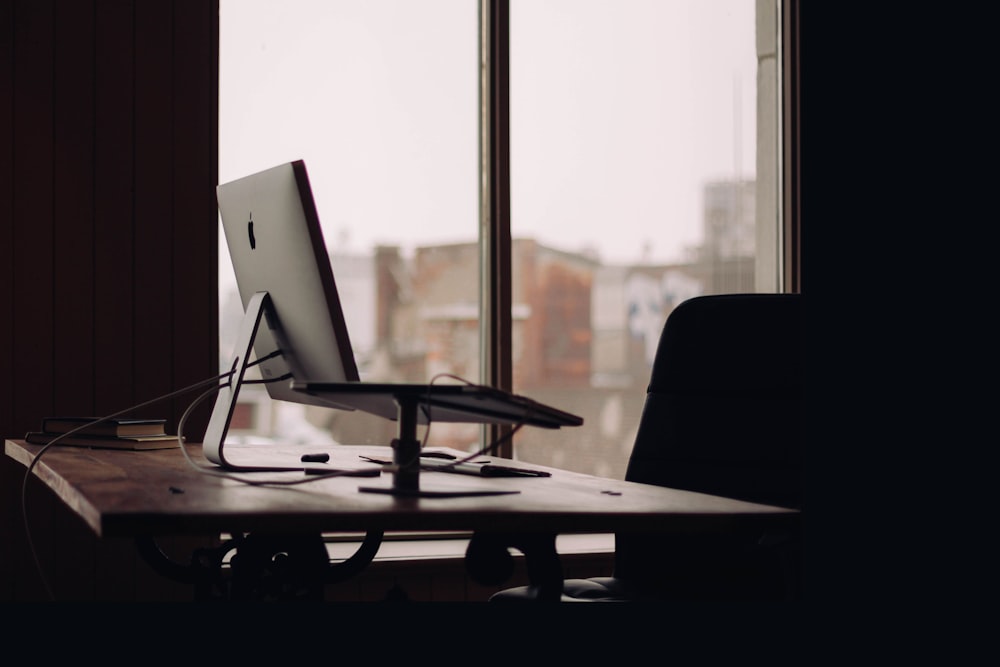 silver iMac on desk inside office