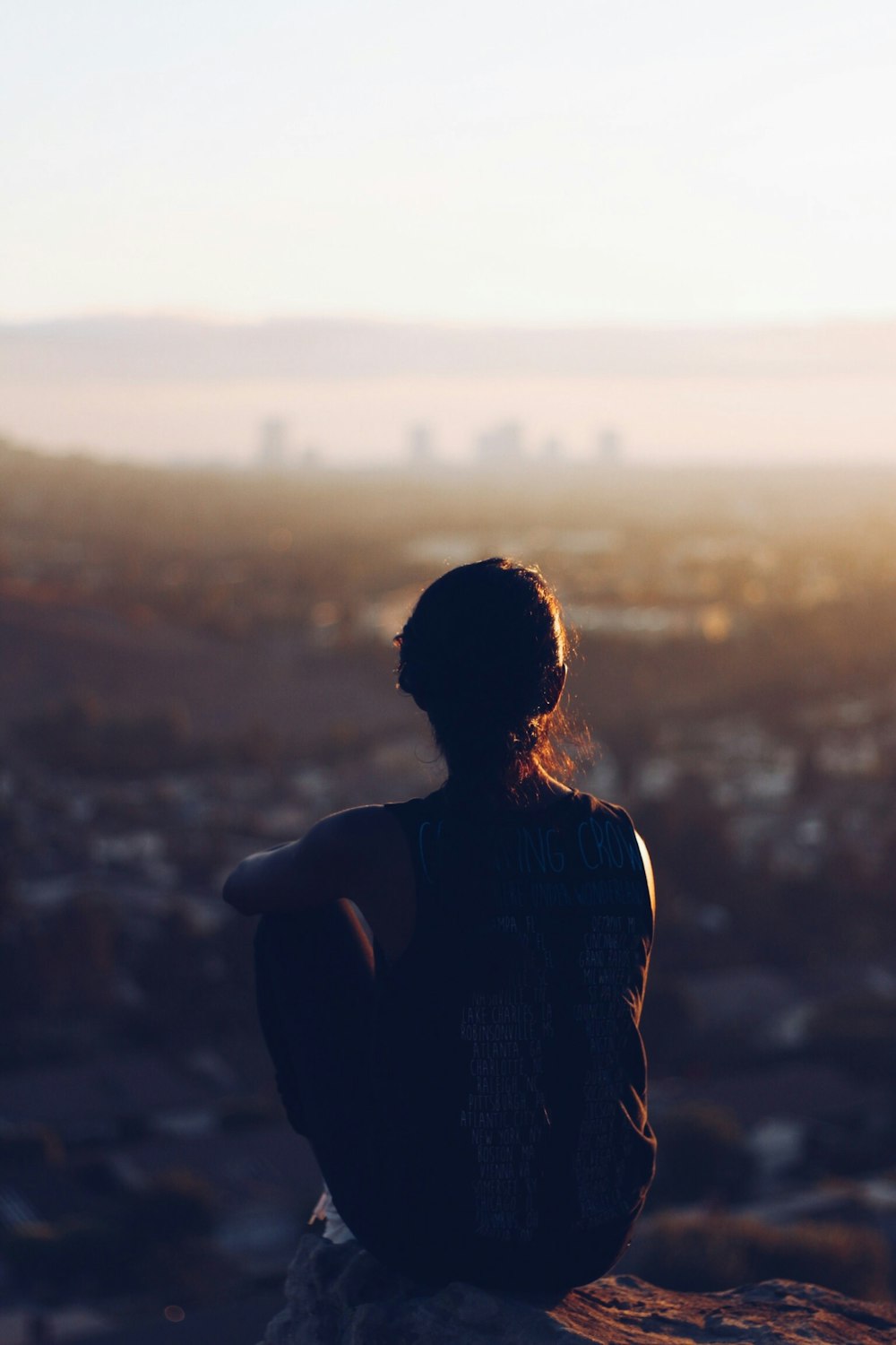 woman sitting on brown rock during daytime