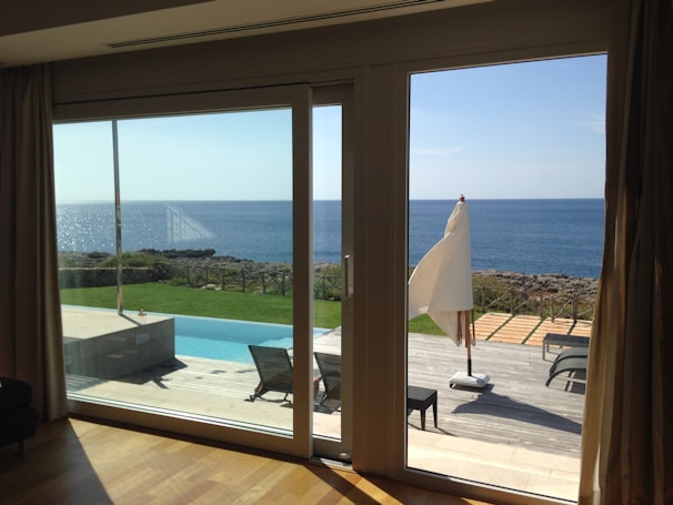 Hotel room with large glass doors opening to a garden patio.