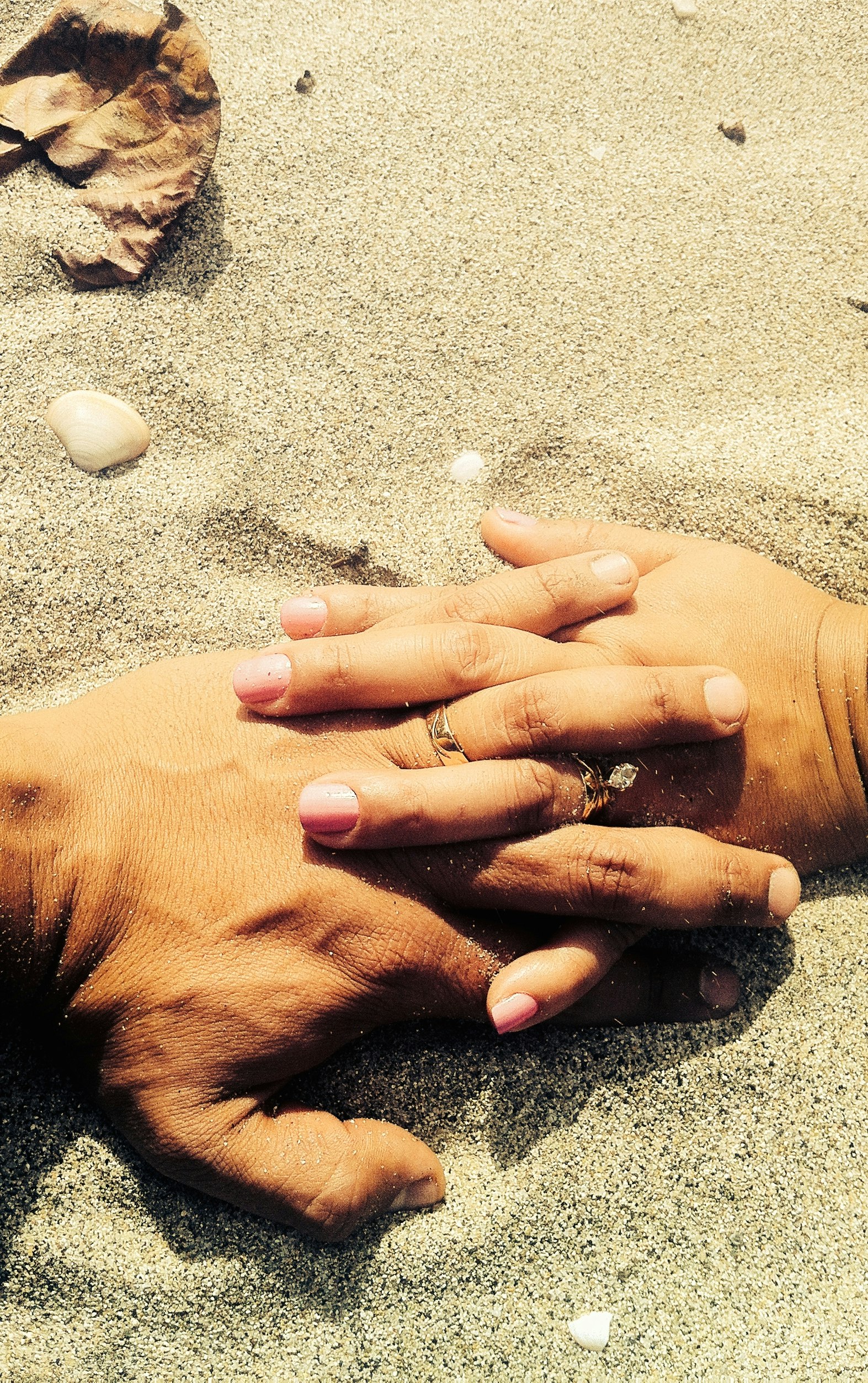 Lovers’ hands on sand