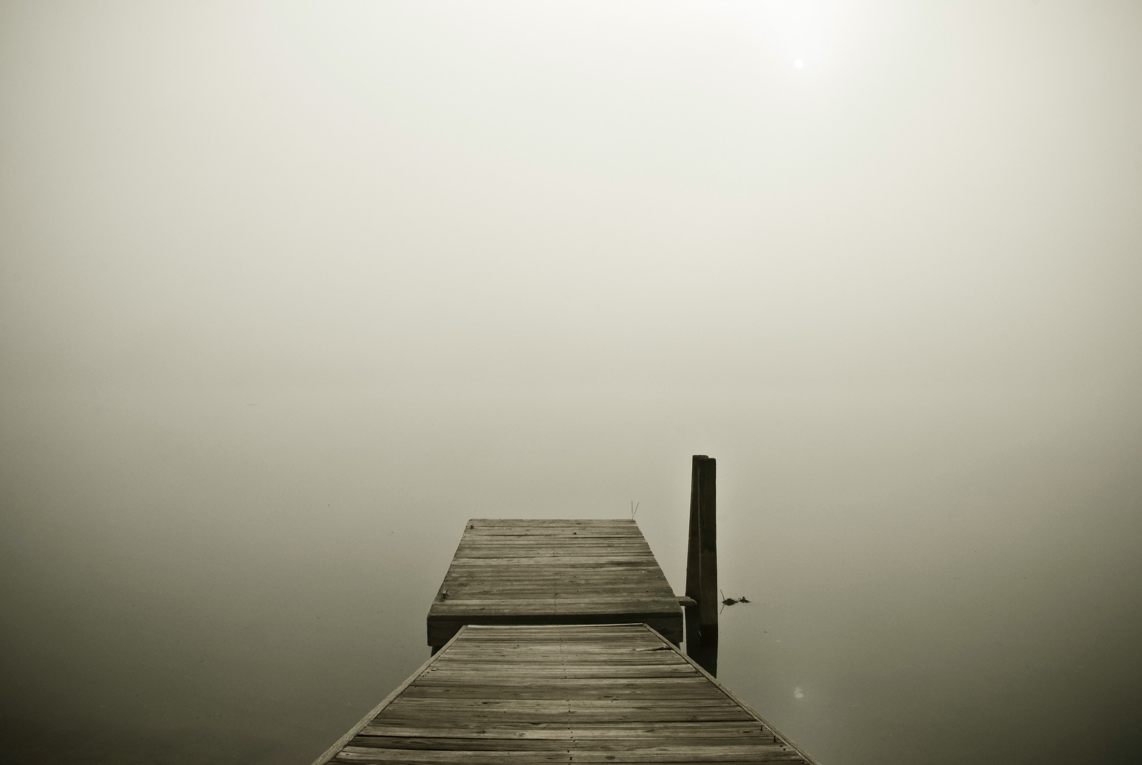 brown wooden pier on cloudy horizon