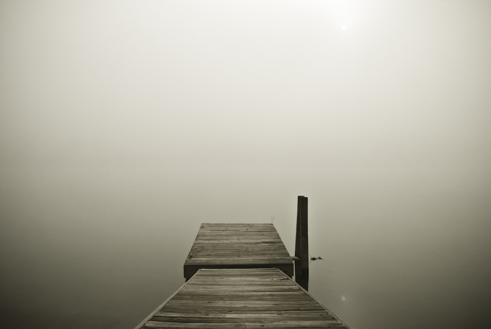 brown wooden pier on cloudy horizon