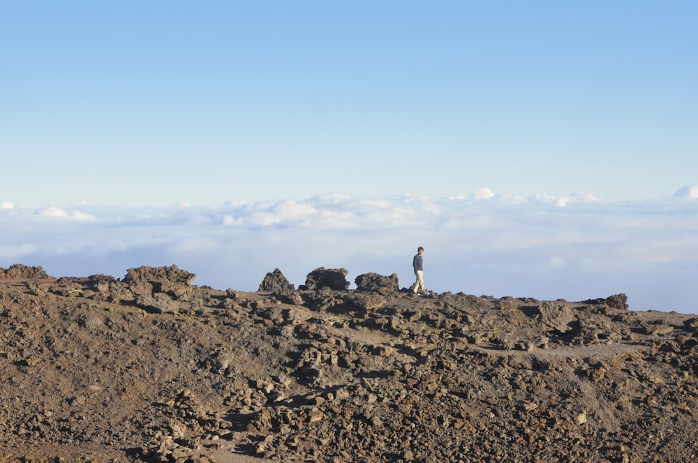 person wearing gray shirt walking under white sky during daytime photography